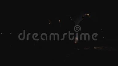 一群人晚上坐在火边的剪影